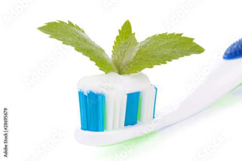 Toothbrush with toothpaste and fresh leaves of mint