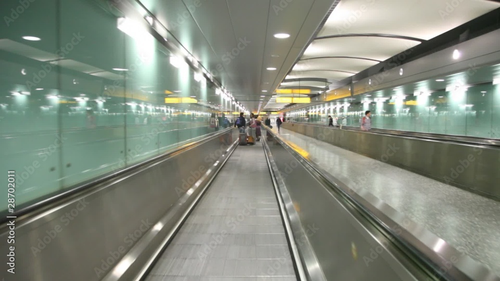 Some people with luggage moving through corridor on elevator Some people with luggage moving through corridor on elevator