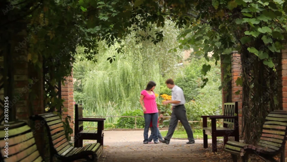 family playing game in plant tunnel of park family playing game in plant tunnel of park