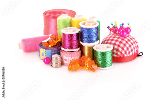 Coloured bobbins of threads, woolen balls and cushion for pins i