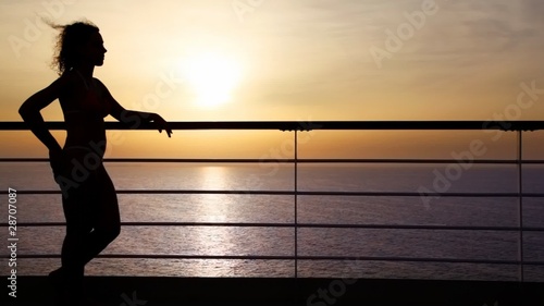 silhouette of woman standing on deck of cruise ship photo