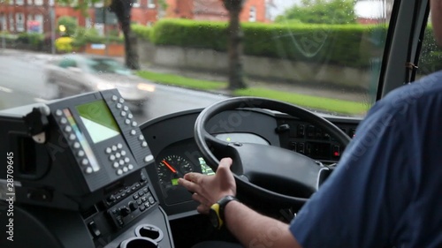 back view of man driving bus on  rainy road photo