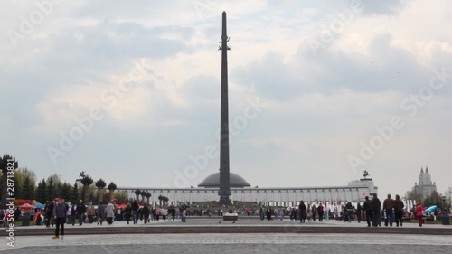 people walks near obelisk in Poklonnaya Hill monument