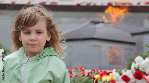 girl standing against eternal fire on monument