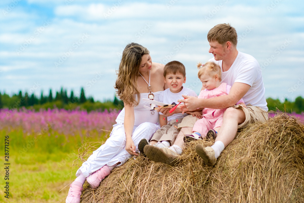 Happy family launching toy aircraft model sitting on haystack to Happy family launching toy aircraft model sitting on haystack to