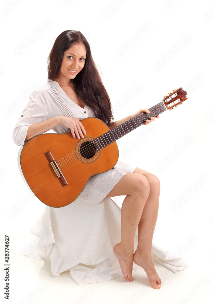 Young beautiful smiling brunette lady in white chemise playing a Young beautiful smiling brunette lady in white chemise playing a