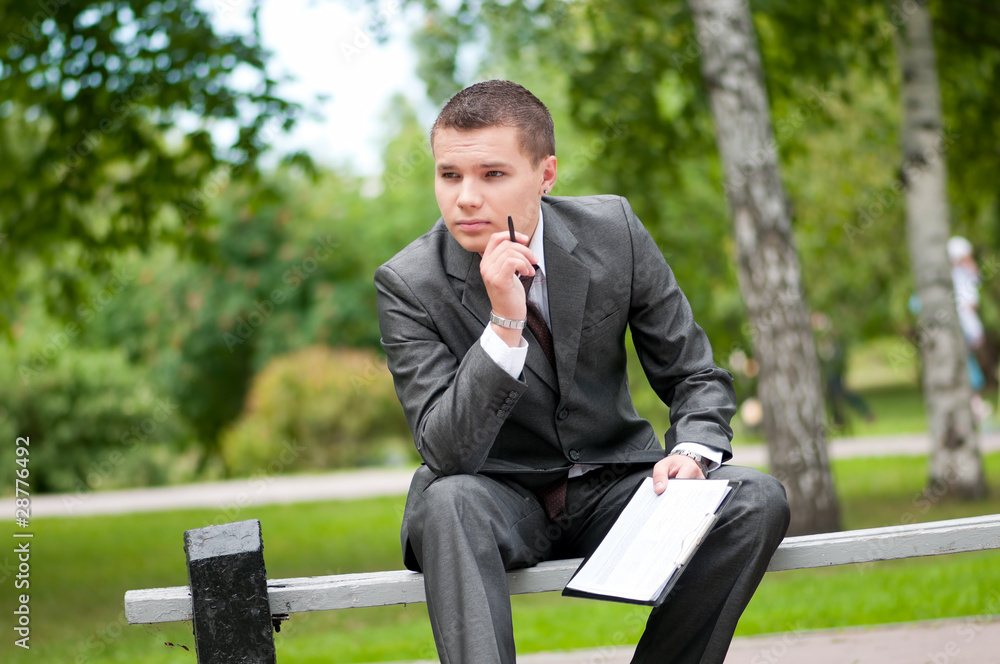 business man working with papers at park. Student business man working with papers at park. Student