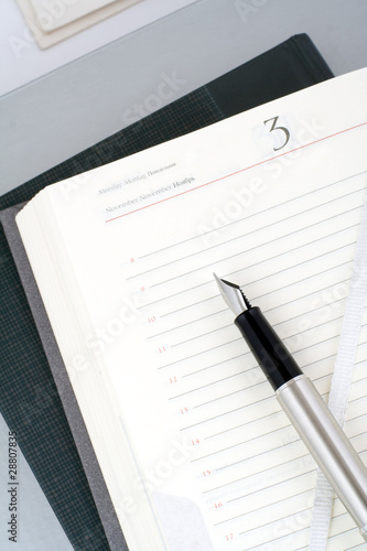 Open organizer and silver pen. Still life.