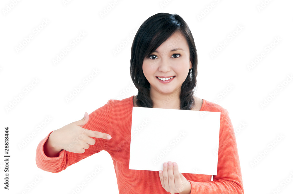 Beautiful young woman holding and pointing at blank note card Beautiful young woman holding and pointing at blank note card