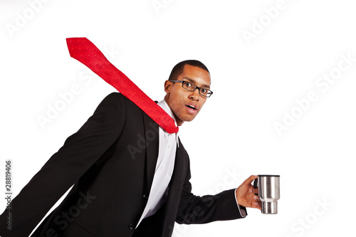 A young businessman runs to work with his coffee.
