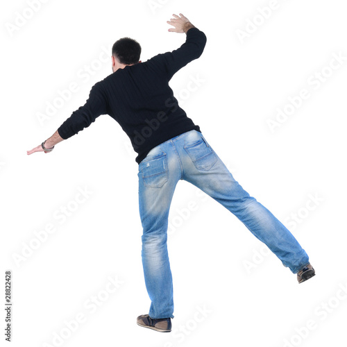 Balancing young man in jacket. Rear view.