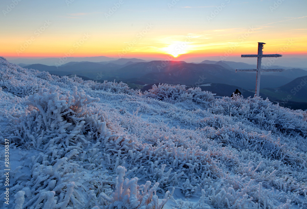 Frosty sunset in mountains with cross