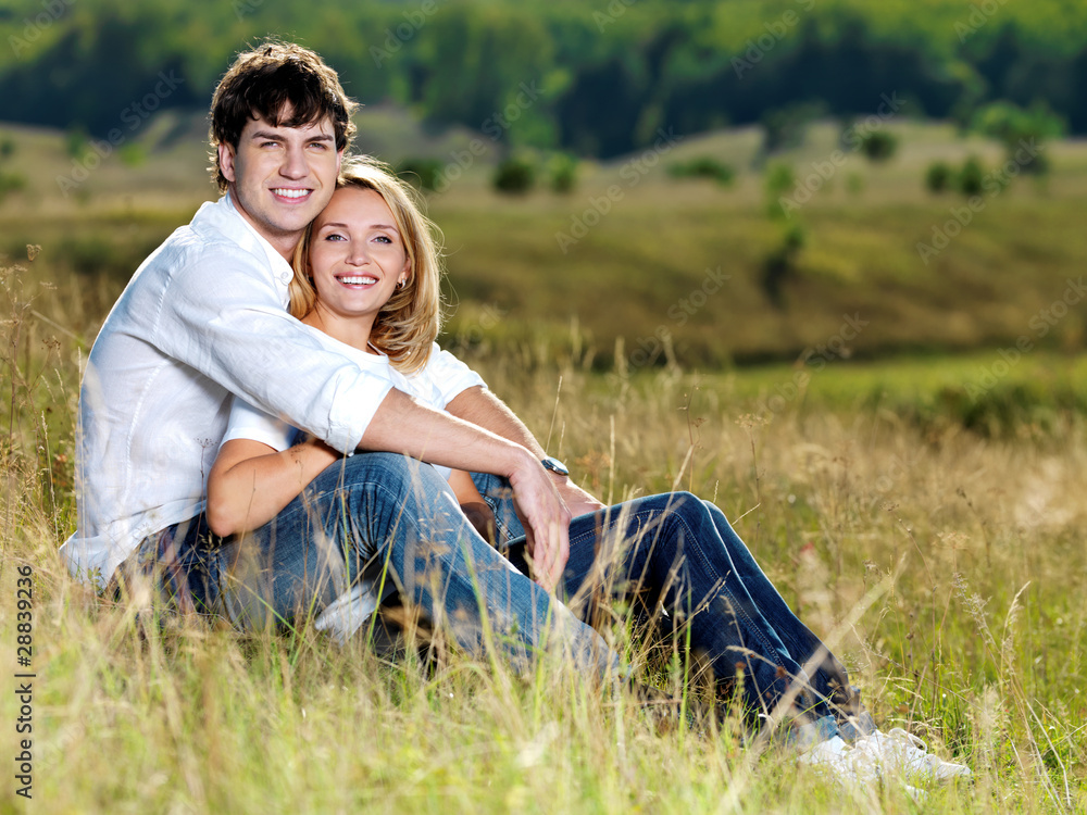 beautiful couple sitting in meadow