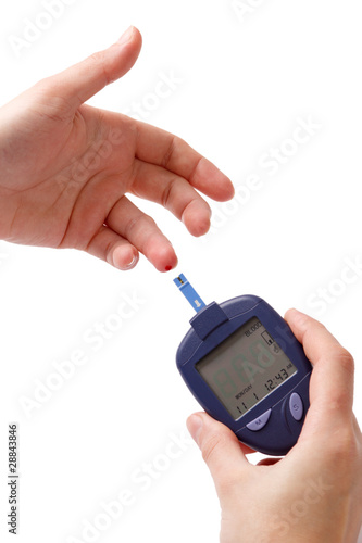 The woman measures glucose level in blood by Glucose Meter