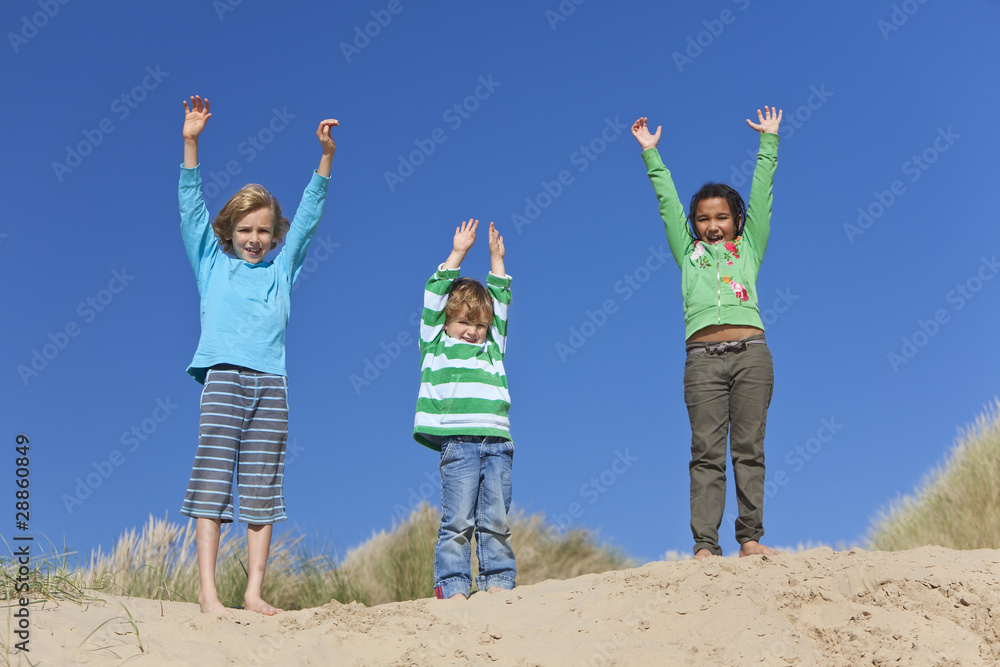 Three Children Arms Raised Having Fun on Beach Three Children Arms Raised Having Fun on Beach