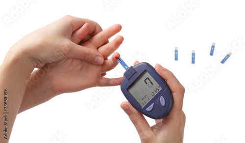Woman checks glucose level in blood at the child