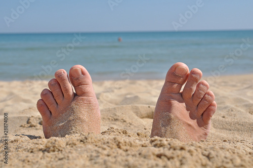 Two feet buried in sand photo