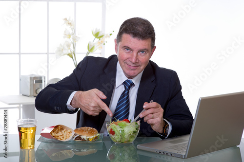 man at office eat green salad healty food