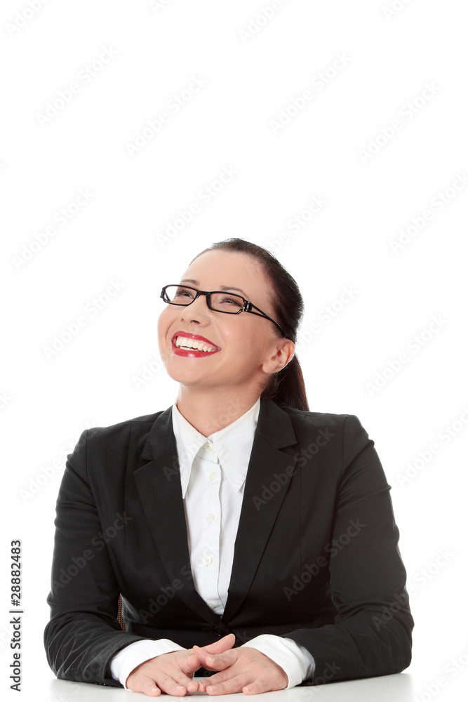 Happy businesswoman behind the desk, looking up Happy businesswoman behind the desk, looking up