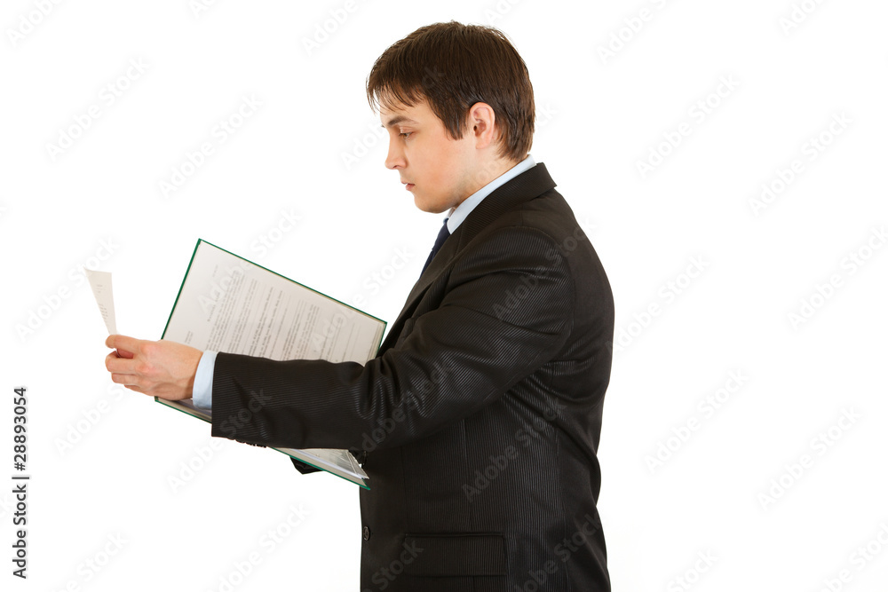 Serious modern businessman holding folder with documents in hand Serious modern businessman holding folder with documents in hand