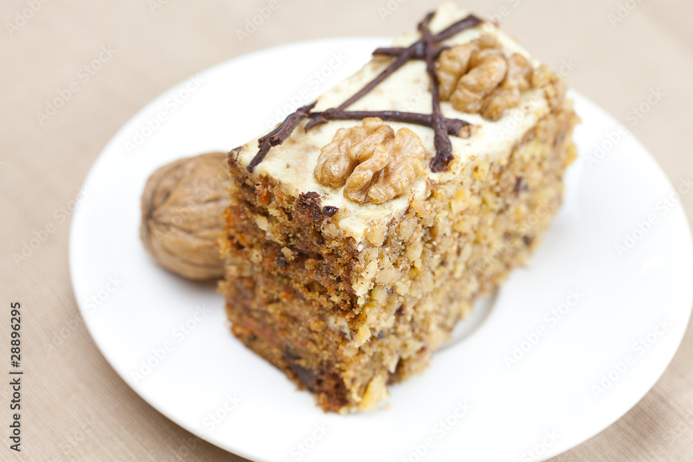 Piece of cake with nuts lying on the plate Piece of cake with nuts lying on the plate