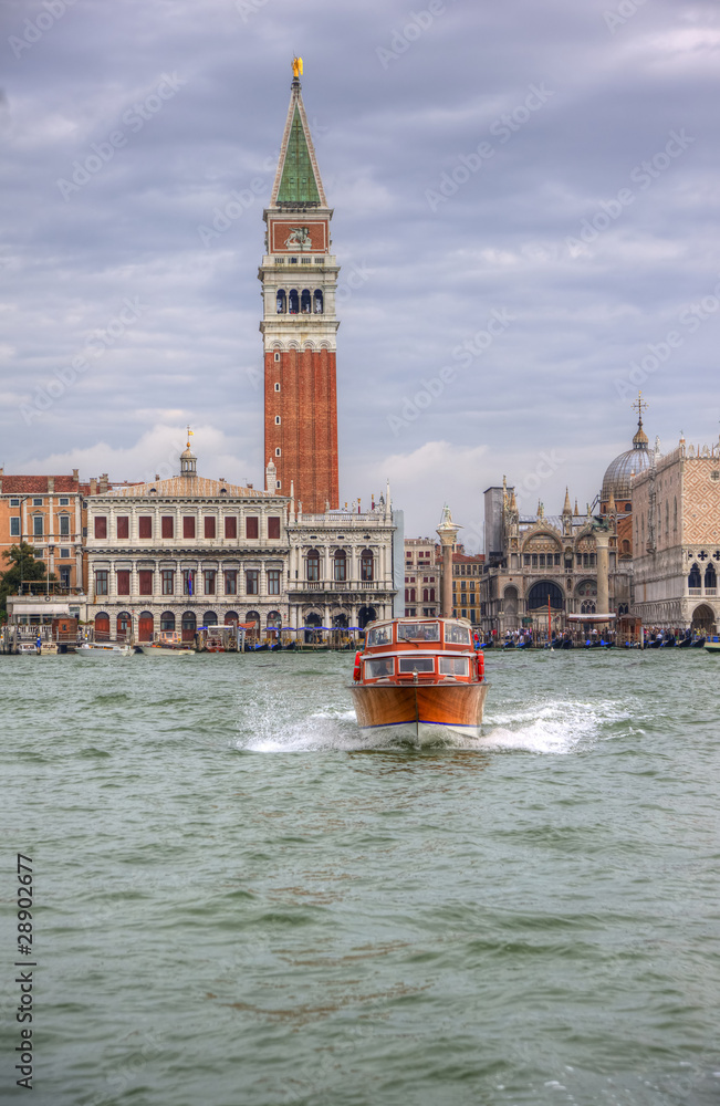 Fototapeta premium Waater taxi crossing Venice Lagoon in Italy with San Marco Piaz