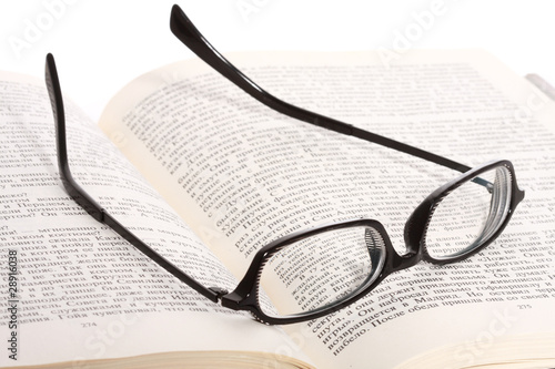 Spectacles lying on the opened book