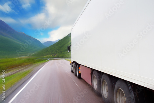 Motion of white semi-truck on the mountain road