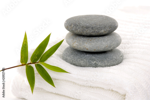 stack of rocks on towel with bamboo leaves