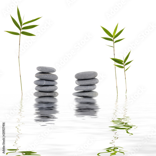 spa stones and bamboo grass with reflection in rippled water,