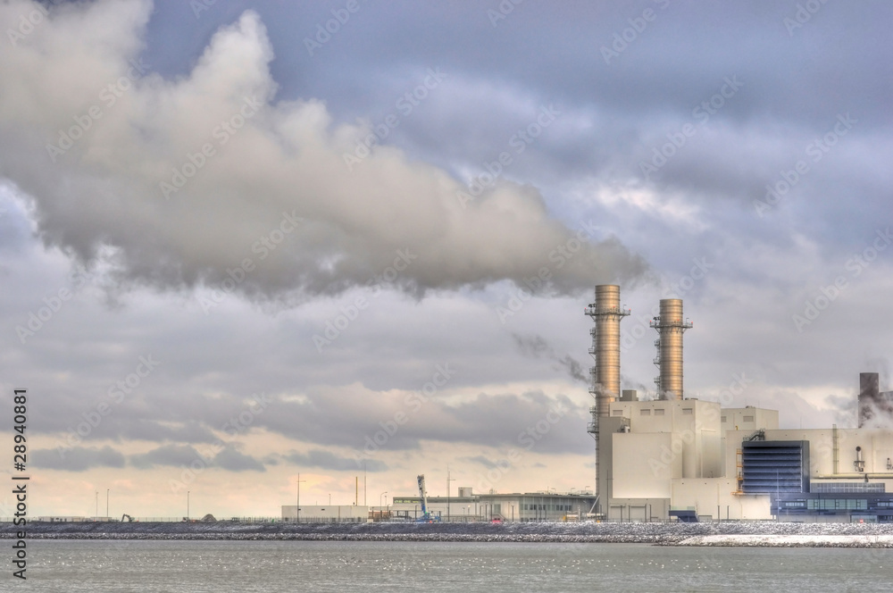 Obraz premium Power station with dramatically clouded and smoky sky