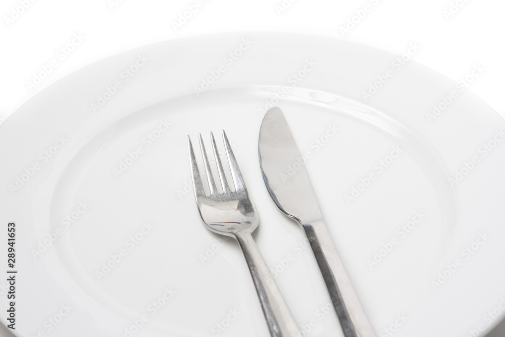 Fork and knife on a white plate Fork and knife on a white plate