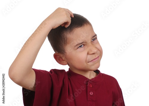 Boy scratching head confused, eight years old