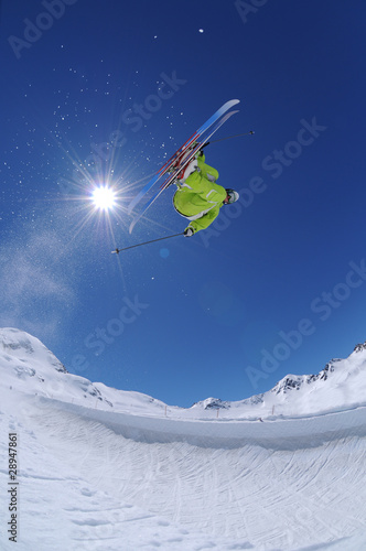 Young freestyle skier jumping high in the mountains
