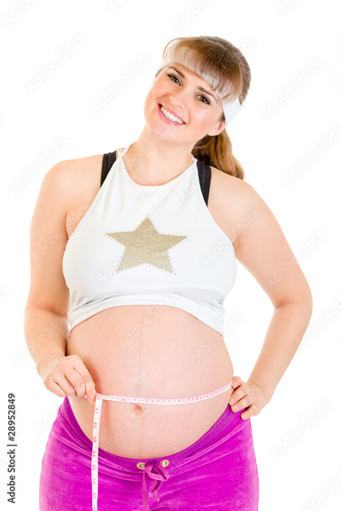 Smiling beautiful pregnant woman measuring her belly Smiling beautiful pregnant woman measuring her belly
