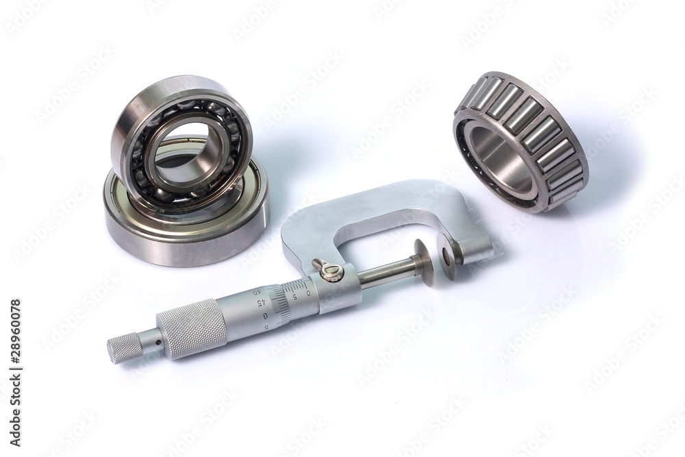 Three ball bearings and micrometer isolated on white background Three ball bearings and micrometer isolated on white background