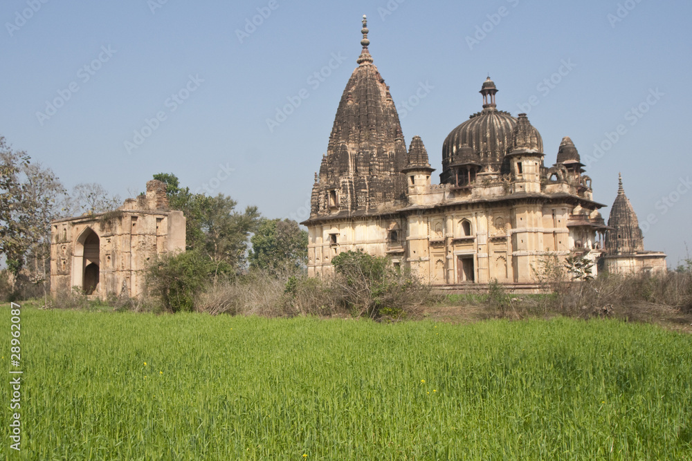 Hindu temple surrounded by lush green fields. Orchha, India