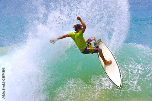 surfer hitting wave lip creates a water curtain spray