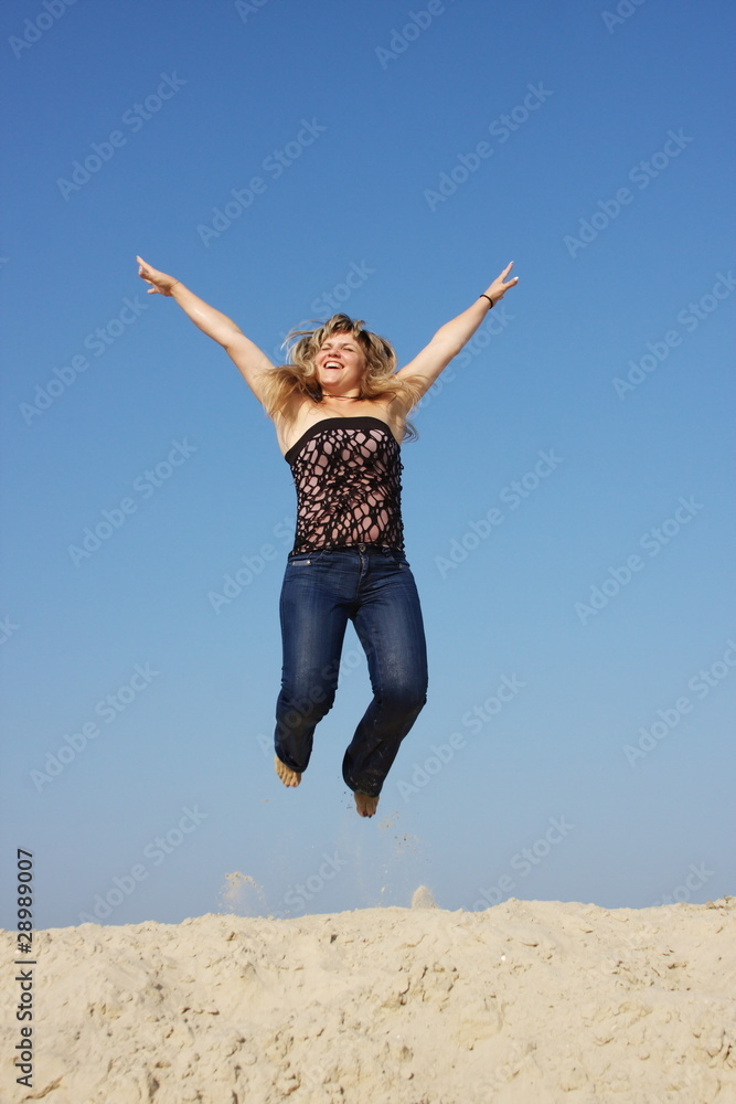 a young woman on nature jumps on a background sky a young woman on nature jumps on a background sky