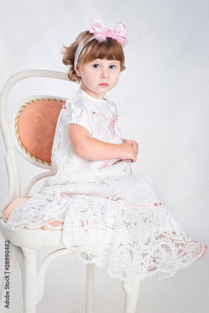 sweet little girl waiting for present sitting on the chair