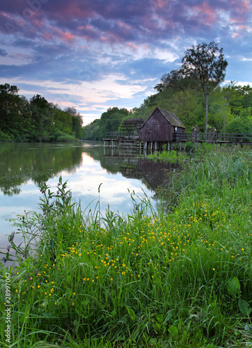 Photo Spring landscape at sunset with watermill and river