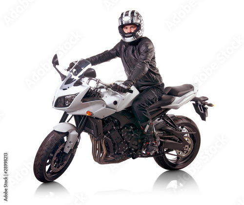 Biker in black leather jacket rides a white motorcycle
