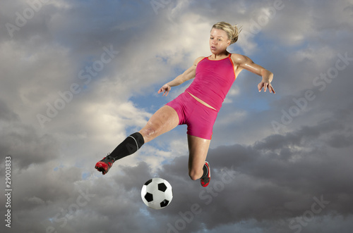 Female Soccer Player Kicking a Ball