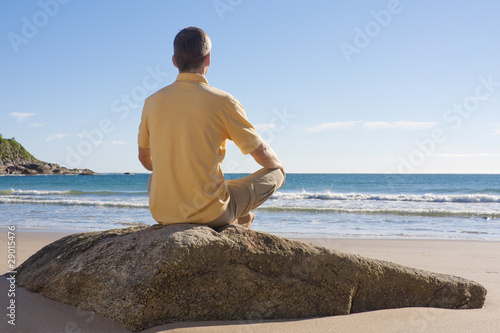Mann meditiert am Meer