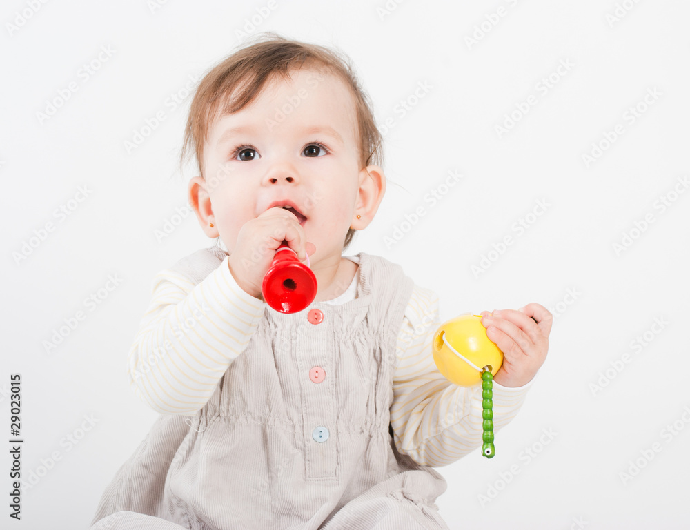 The little girl plays with wooden toys a white background The little girl plays with wooden toys a white background