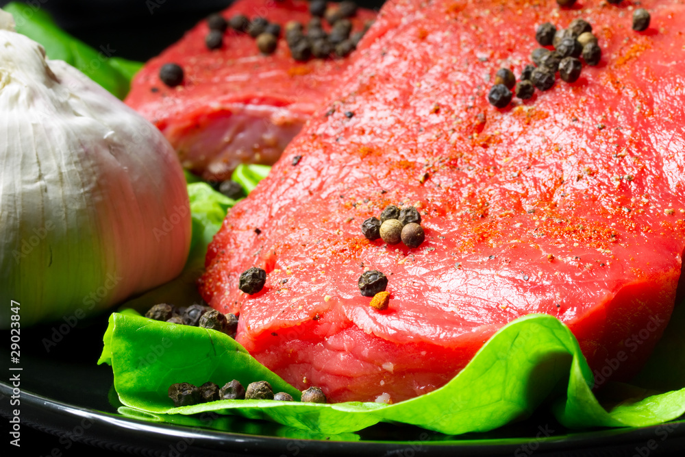 Raw beef steak with black pepper and garlic Raw beef steak with black pepper and garlic
