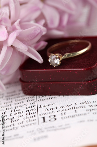 Engagement ring on the Bible open to 1st Corinthians 13