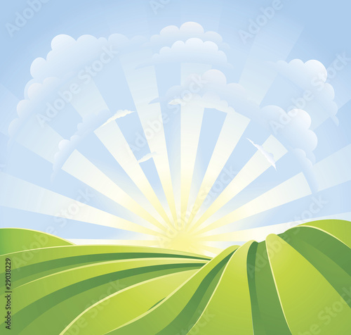 Idyllic green fields with sunshine rays and blue sky