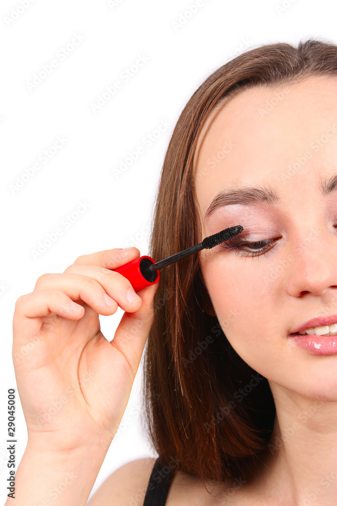 Fototapeta premium Young beautiful girl applying mascara