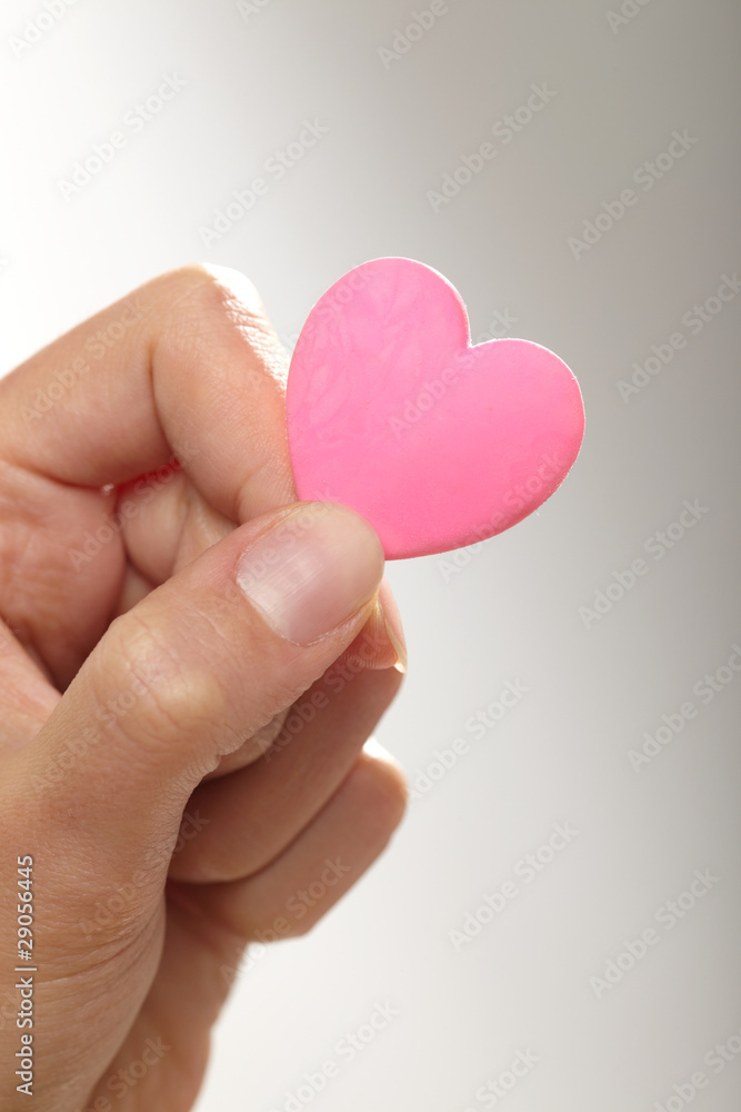 Obraz premium Woman holding pink heart in the hand